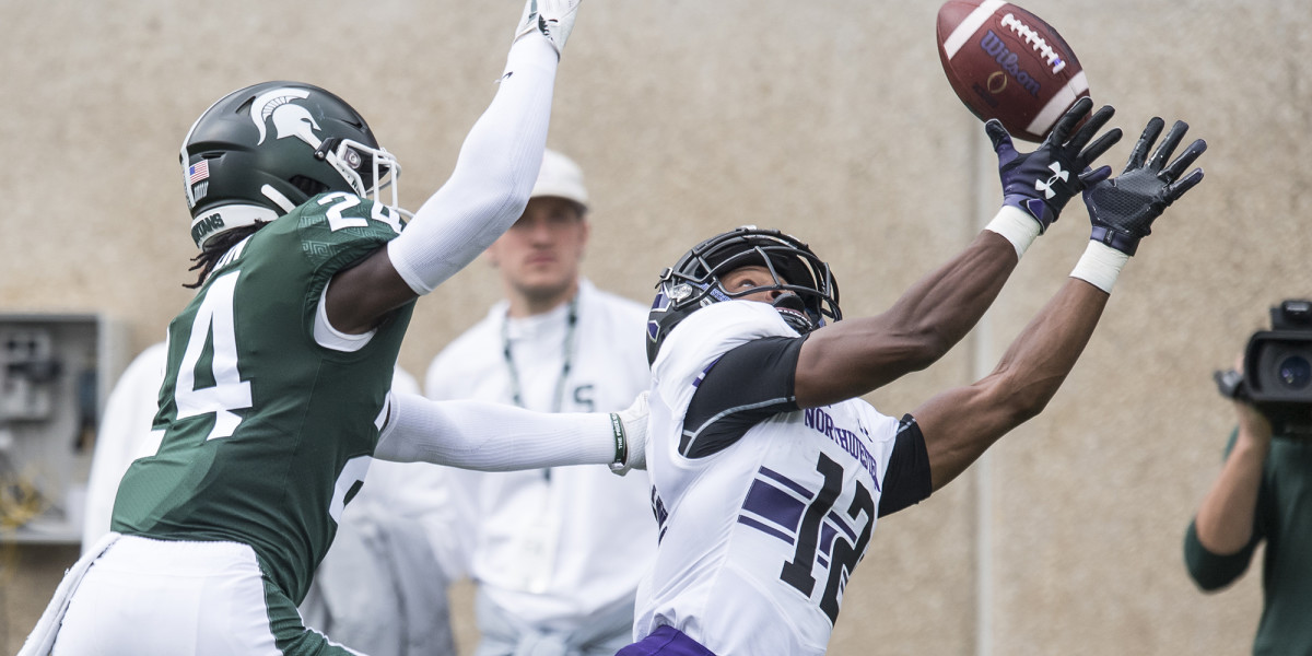 JJ Jefferson extends for the over the shoulder grab over the Michigan State Spartan.